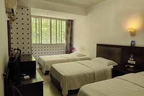 A hotel room with two beds, a desk, a TV, and a window with curtains. - Caizi Hostel (Huangshi)