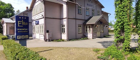 A two-story hotel with a sign reading "Elina Viesnica" and "Kafejnica."