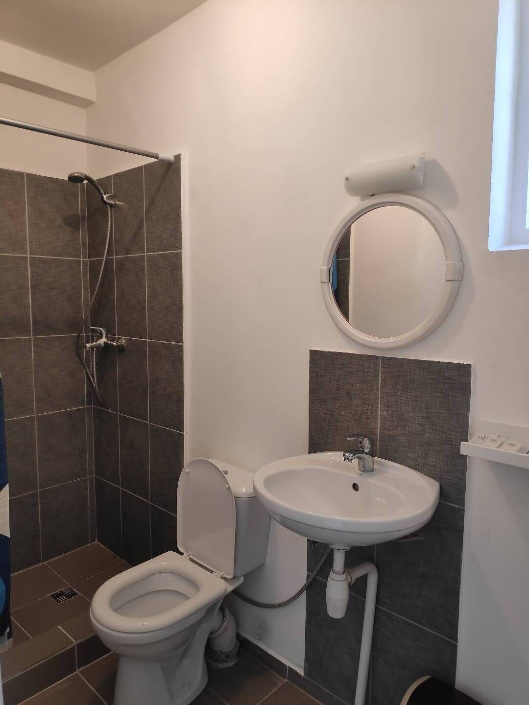 A bathroom with a toilet, sink, and shower.