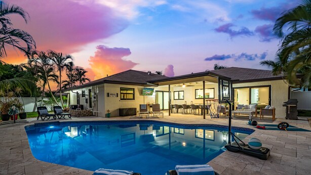 Une piscine avec des chaises longues et un espace patio.