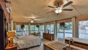 A bedroom with a bed, a desk, a chair, a dresser, and a window. - Eclectic Forest View Efficiency in Quiet Chapel Hill Neighborhood (Chapel Hill)