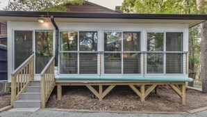 A small, single-story building with a covered porch and a wooden staircase leading to a door. - Eclectic Forest View Efficiency in Quiet Chapel Hill Neighborhood (Chapel Hill)