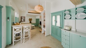 A kitchen with teal cabinetry, white countertops, and a hanging light fixture. - La Casa Degli Archi (Kos)