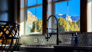 A kitchen with a large window overlooking a mountainous landscape. - Moonlight Lodge |  Private Hot Tub | Zion NP (Orderville)