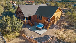 A log cabin with a deck, outdoor seating, and a hot tub. - Moonlight Lodge |  Private Hot Tub | Zion NP (Orderville)