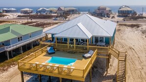 Une maison située en bord de mer, dotée d’une piscine, d’une terrasse et offrant une vue sur l’océan.