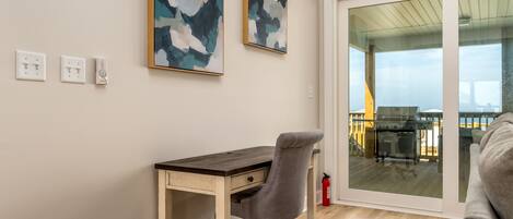 A modern room with a wooden desk, a grey office chair, and abstract art on the wall.