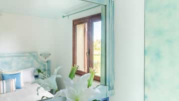 A bedroom with a bed, a mirror, and a window.