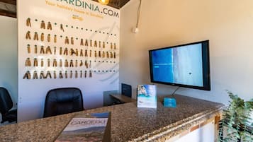 A reception desk with a display of keys, a monitor, and a brochure.