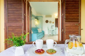 A table with a pitcher of lemonade, two white mugs, and a plate with two pastries. -  Museddu Beach ground floor in residence with a pool (Cardedu)