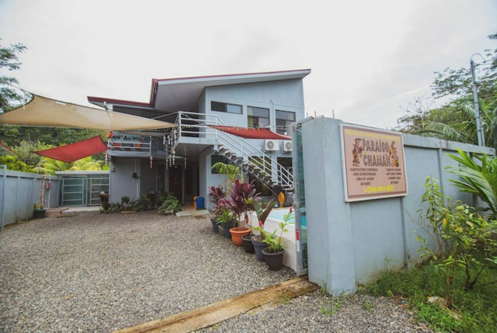 Un bâtiment à deux étages doté d’une entrée couverte, d’un espace extérieur aménagé pour s’asseoir et d’une enseigne.