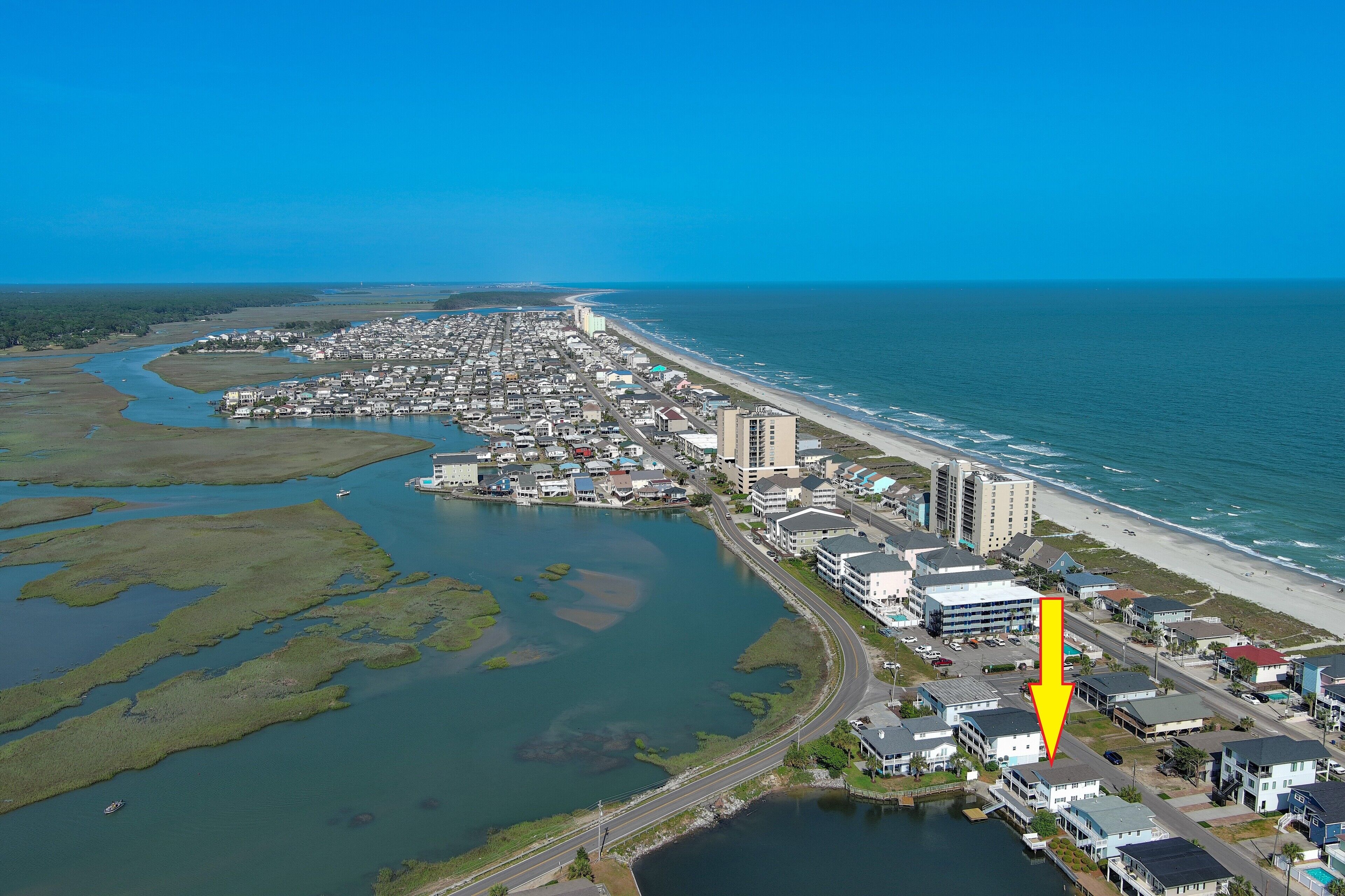 Vue aérienne d’une ville côtière avec une rivière, des bâtiments et une plage.