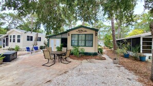 A small, single-story mobile home with a patio area featuring a table and chairs. - Newly updated in family/pet friendly resort with all the amenities - near beach! (Nokomis)