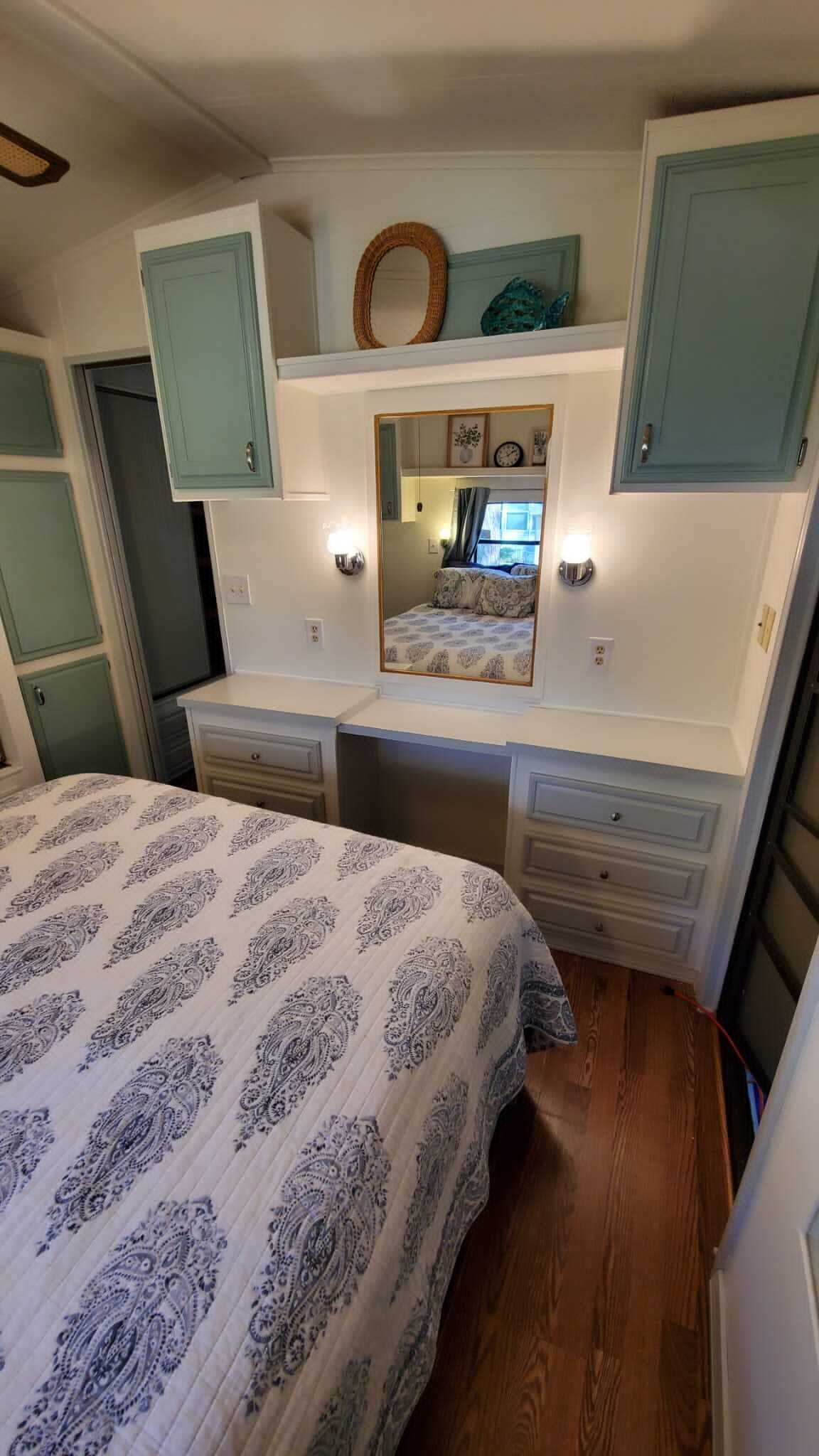 A bedroom with a bed, a dresser, a mirror, and a door.