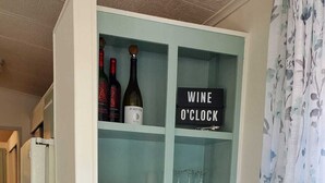 A kitchen with a built-in wine rack, a coffee maker, and a sign that reads "WINE O'CLOCK". - Newly updated in family/pet friendly resort with all the amenities - near beach! (Nokomis)