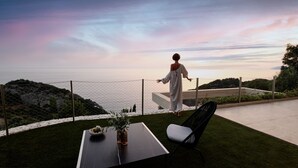 A person standing on a balcony overlooking a scenic view.