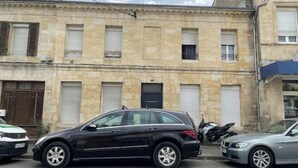 Ein Gebäude mit mehreren Garagen und einem schwarzen Auto.