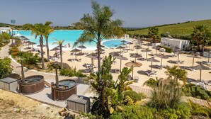 Resort com uma piscina grande, vários espreguiçadeiras e área de spa em madeira.