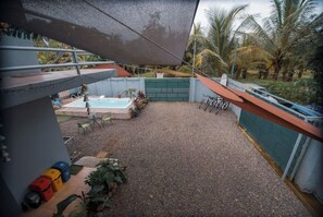 Relax by the pool in a secure, tranquil space surrounded by palm trees.