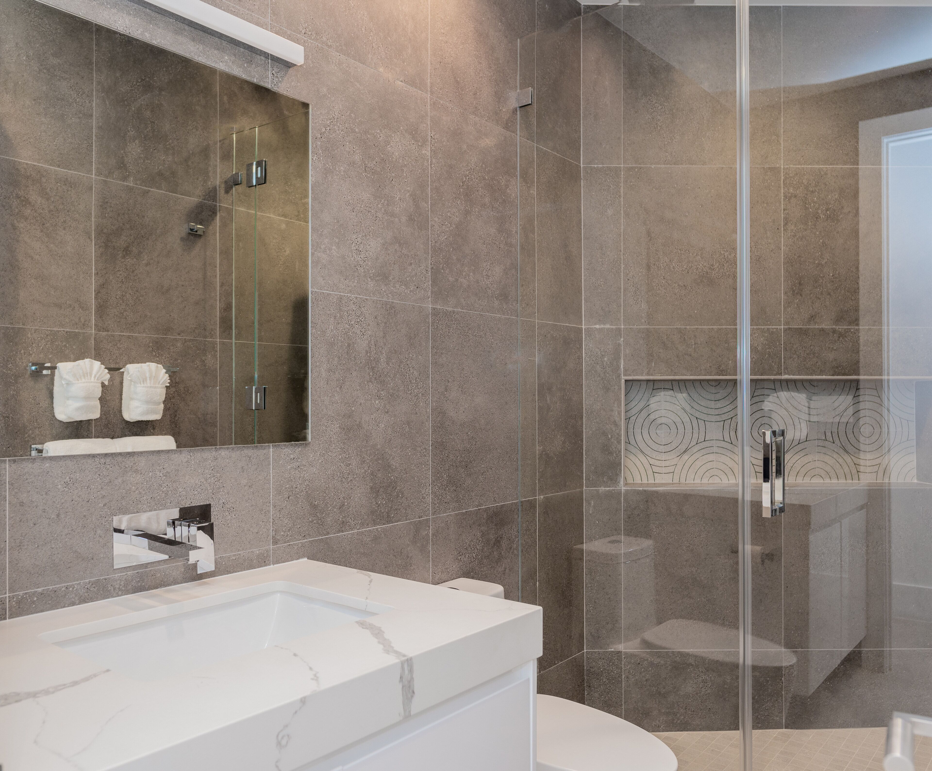 Ein modernes Badezimmer mit einer großen weißen Badewanne, einer Duschkabine und einem Spiegel über dem Waschbecken.