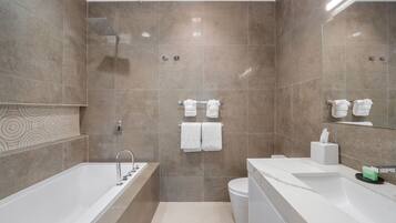 A modern bathroom with a bathtub, toilet, and sink.
