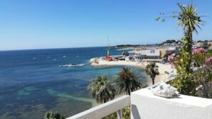 Blick auf die Küste mit Strand, klarem blauen Meer und einigen Booten.