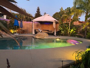 A swimming pool with a hot tub, lounge chairs, and umbrellas. - Beautiful Mediterranean Cottage on larger estate. (Santa Barbara)