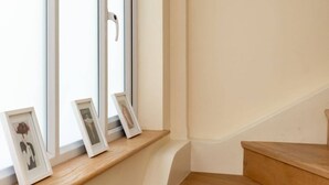 A staircase with wooden steps leading to a landing. - Modern and Bright 3 Bedroom House in Paddington (London)