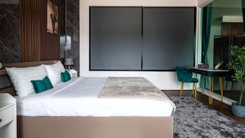 A modern bedroom with a large bed, a desk, and a chair.
