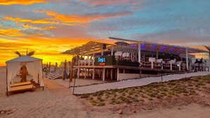 Un restaurant situé en bord de mer, avec une terrasse et un auvent.