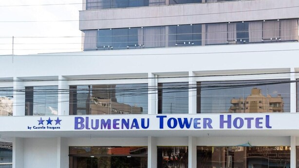 Die Fassade des Blumenau Tower Hotels mit modernem Design, ausgestattet mit großen Fenstern und einer gut sichtbaren Beschilderung.