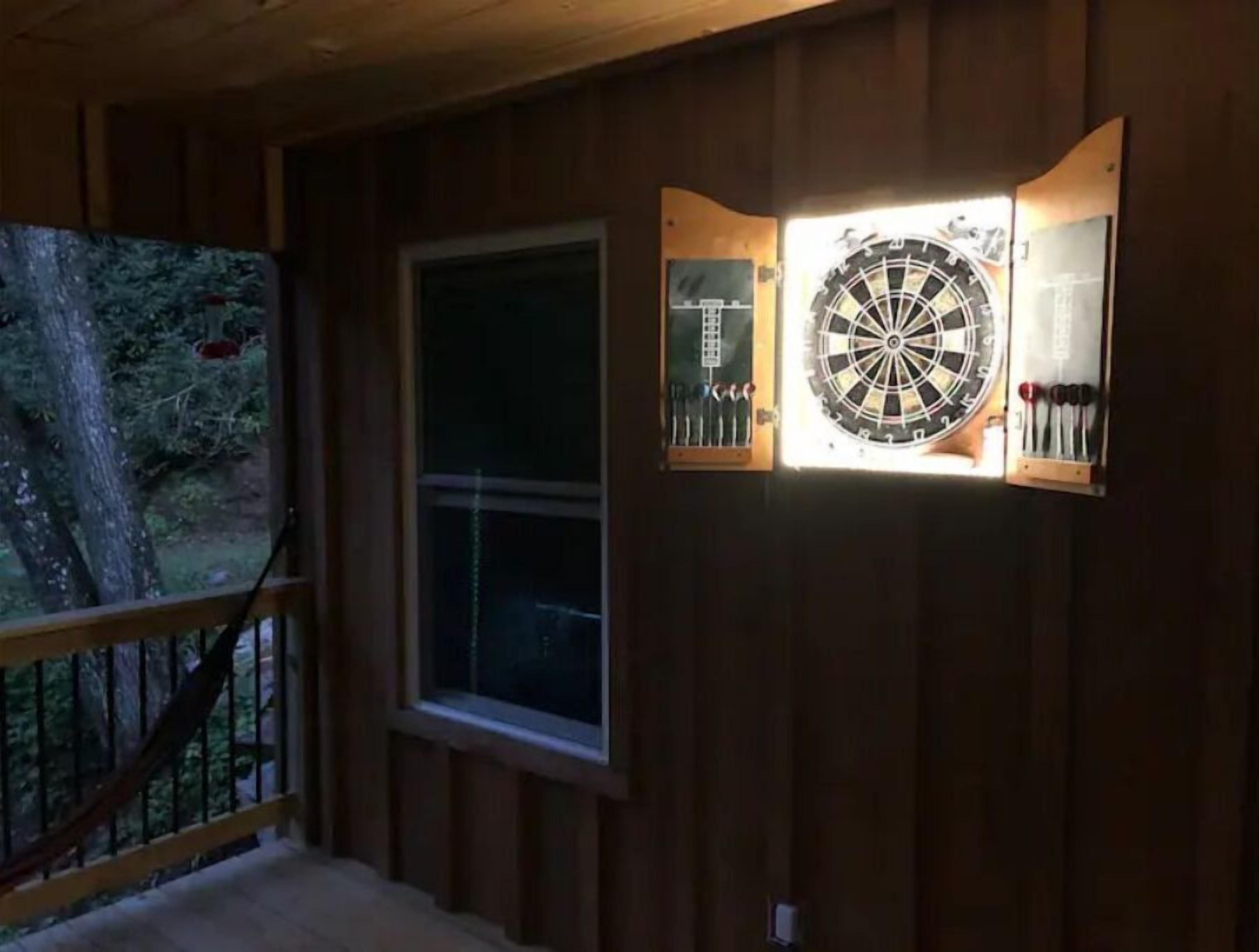 A dartboard mounted on a wall with a window nearby.