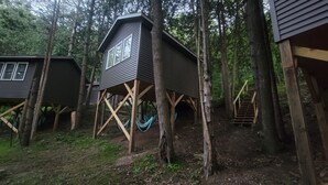 Un bosque con casas construidas entre los árboles sobre pilares de madera.