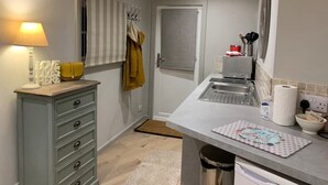 A compact kitchen with a sink, a countertop, and a cabinet.
