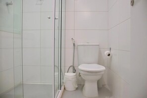 A bathroom with a glass shower enclosure, a toilet, and a bidet. - Apart no Puerto Ventura por Carpediem (João Pessoa)