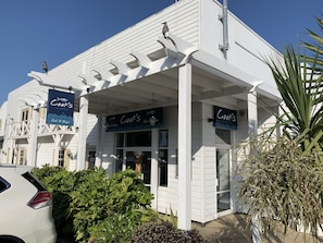 A white building with a covered porch and signs for 'Cook's of Poole' offering fish & chips. - Prosecco Palace (Poole)