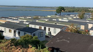 A row of mobile homes with a lake view. - Club Tropicana (Poole)