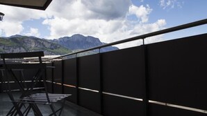 Un balcón con vistas a montañas y un cielo despejado.
