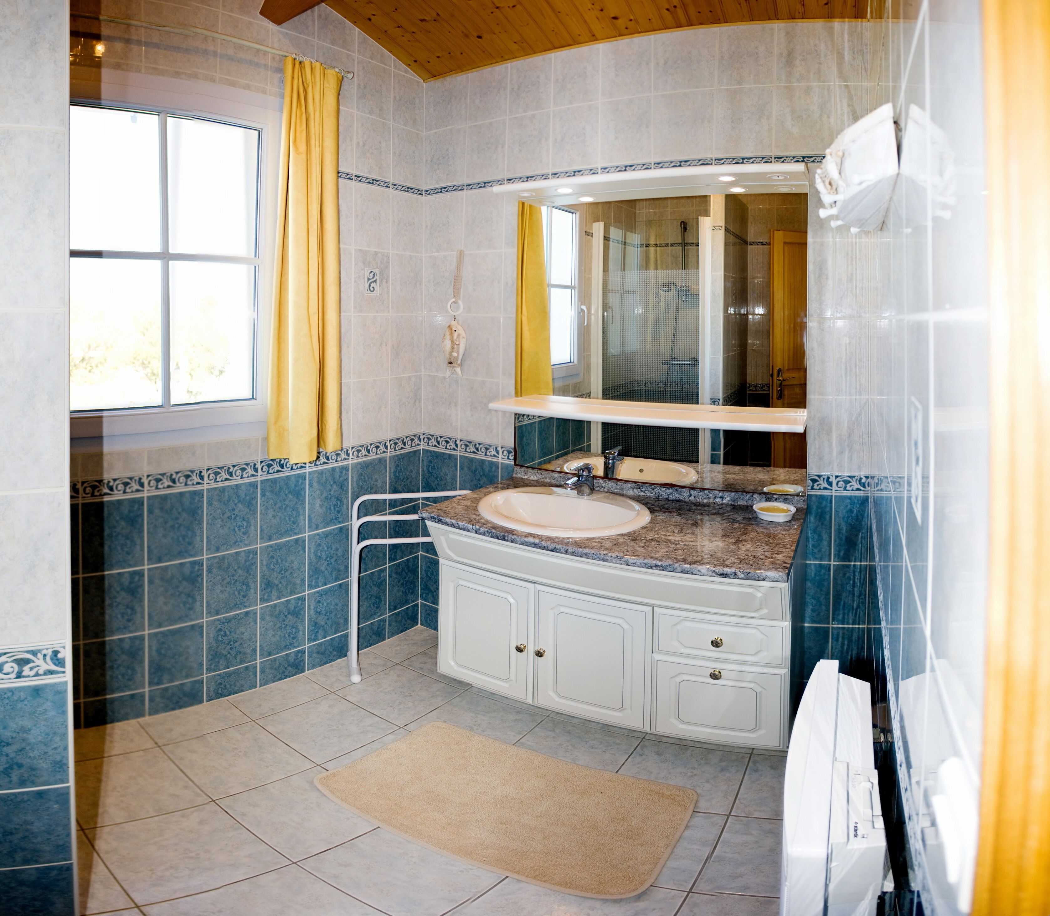 A bathroom with a sink, mirror, and shower.