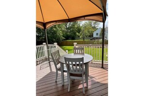 Relax in an outdoor space with a covered seating area featuring a round table and four chairs.