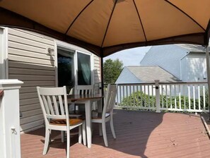 Relax in a sheltered outdoor space with a table and two chairs under a spacious canopy.
