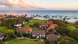An aerial view of a coastal residential area with houses, palm trees, and a beach. - Steps from Beach, Stunning View, A/C, Pool Access (Koloa)