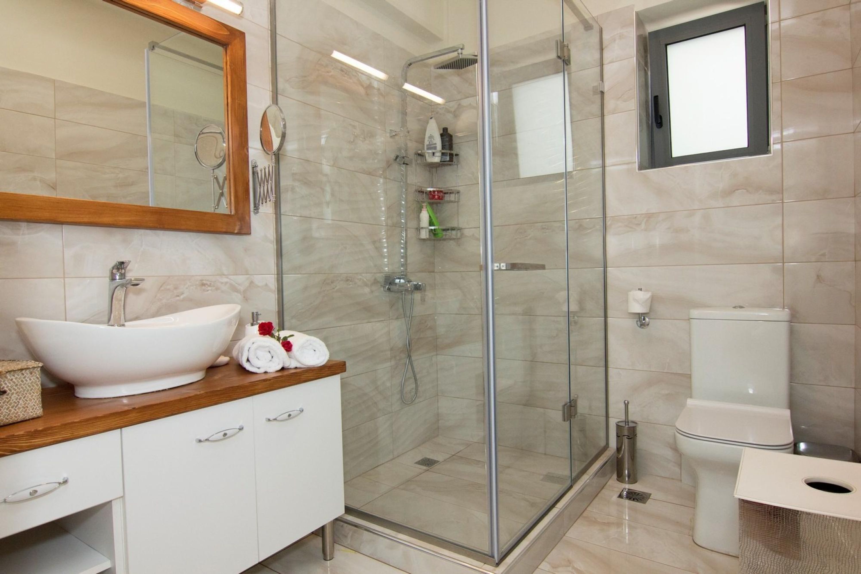 Une salle de bain moderne avec une douche à parois de verre, un lavabo blanc et des toilettes.
