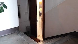 Un corridoio con una porta in legno che dà su una stanza.