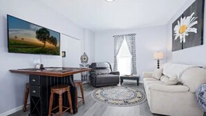 Un salon équipé d’un téléviseur, d’un bureau, d’un canapé et d’une table basse.