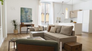 Een moderne woonkamer met een modulaire bank, een klein tafeltje en een houten kist.