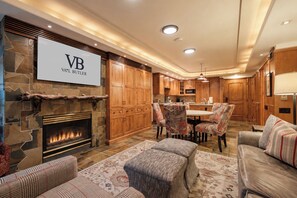 A spacious living area with a fireplace, a dining table with chairs, and a sofa.