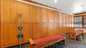 Un vestiaire en bois avec des bancs et un porte-bâtons de ski.