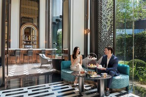 A modern indoor setting with a seating area, a bar, and a view of the outdoors.