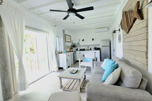 Relax in this open-plan living space with a sofa, coffee table, and kitchen area.